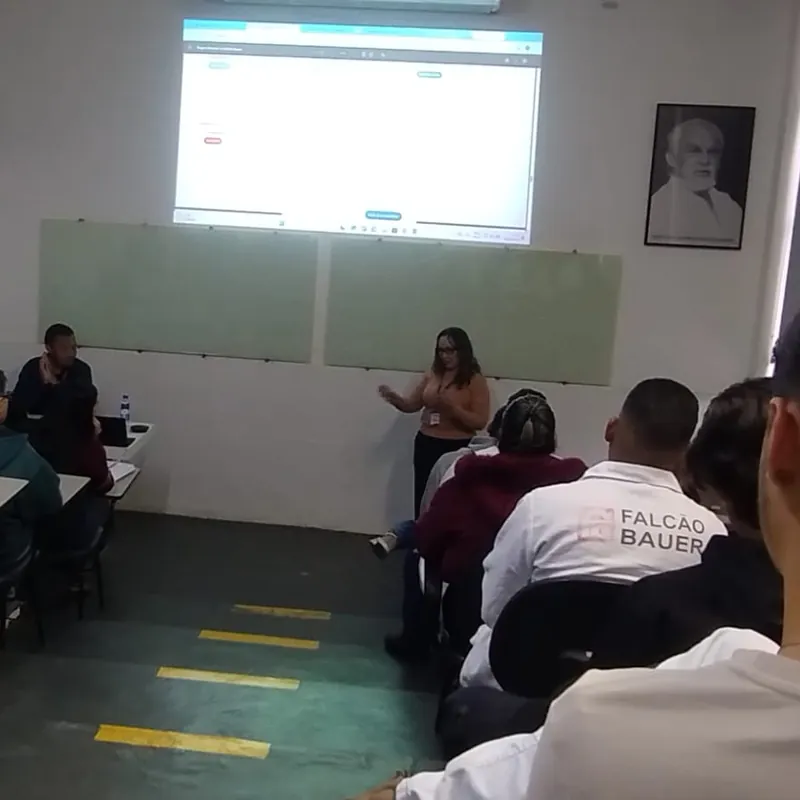 Palestra na Falcão Bauer, com a plateia sentada em sala de aula